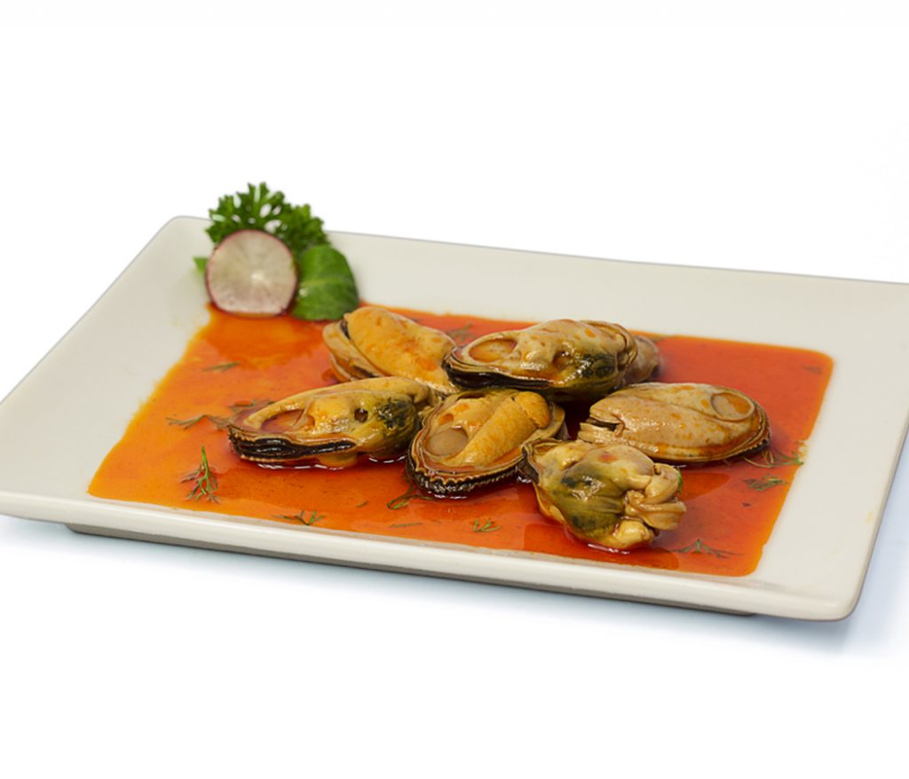 Almejas en salsa roja servidas en plato blanco
