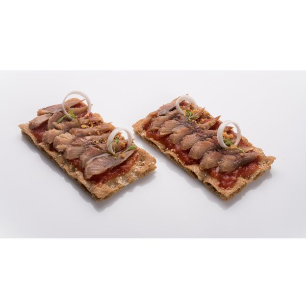 Tostas de arencon ahumado con tomate, aros de cebolla y hierbas aromáticas