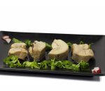 Rodajas de alcachofa sobre rúcula en plato negro